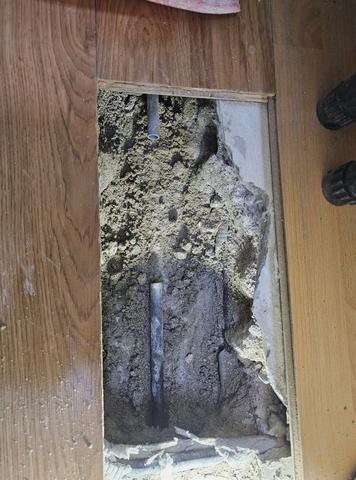 누수탐지 작업 사진: 마루를 직사각형으로 걷어 낸 바닥 속에 배관이 보이는 모습